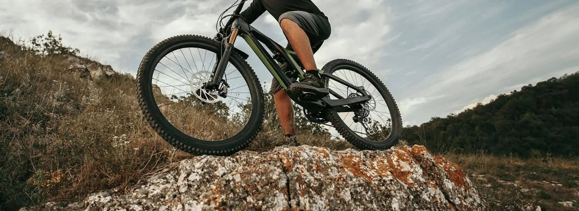 Cyclist rides over a rock